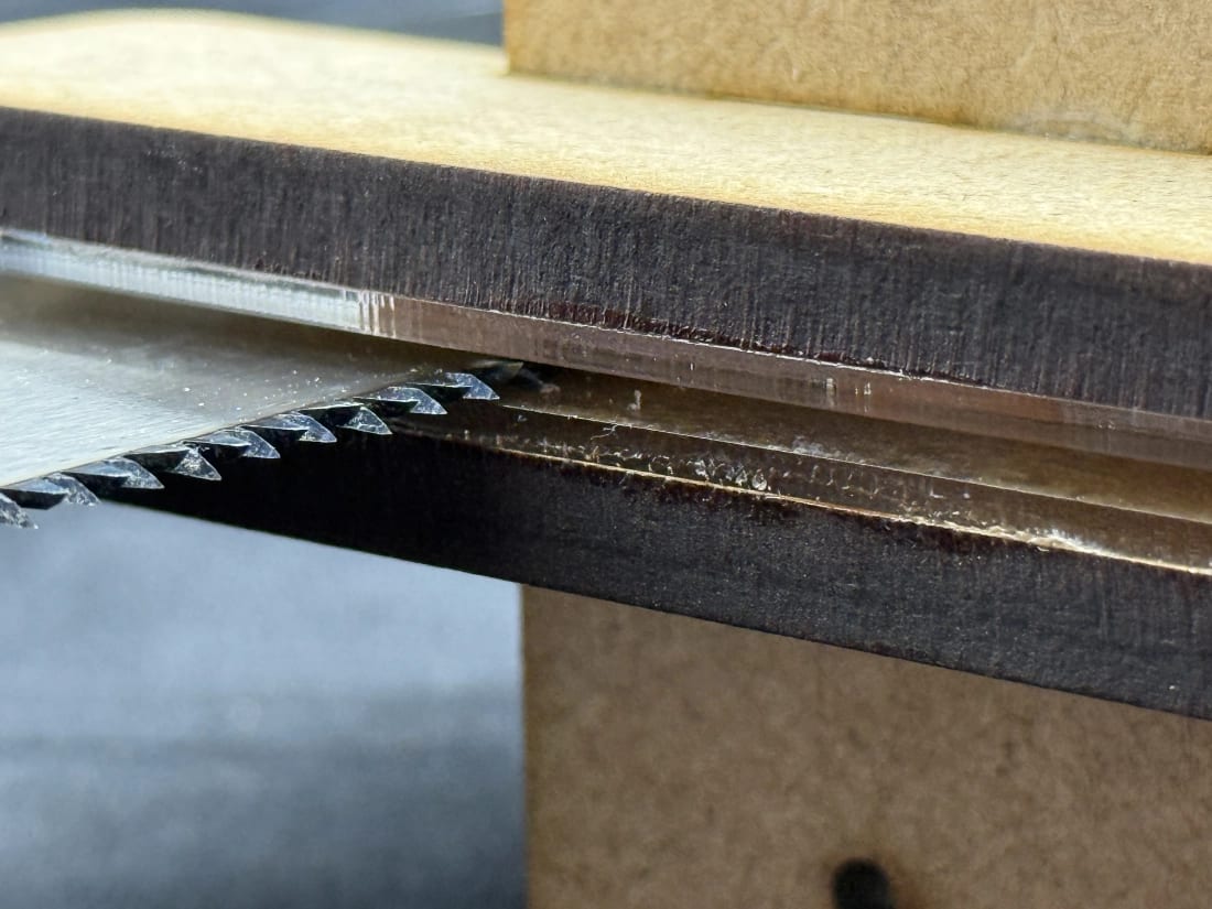 Acrylic guide faces on TrueNewel saw guide beside a hand saw blade