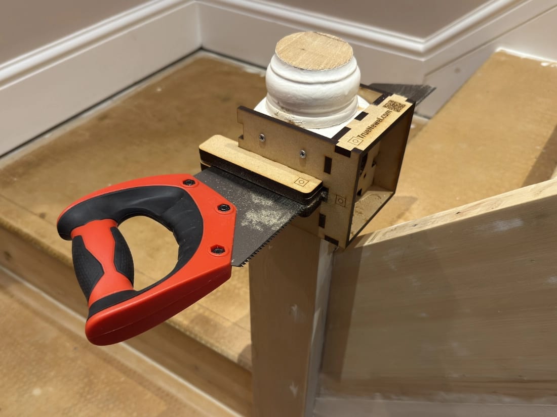 TrueNewel 90 screwed to a 90mm stair newel post with a hand saw in the guide